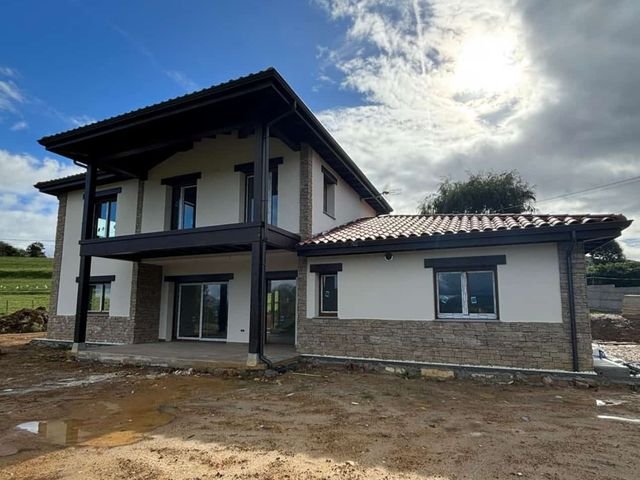 Vivienda de dos plantas con balcón y zócalo de piedra